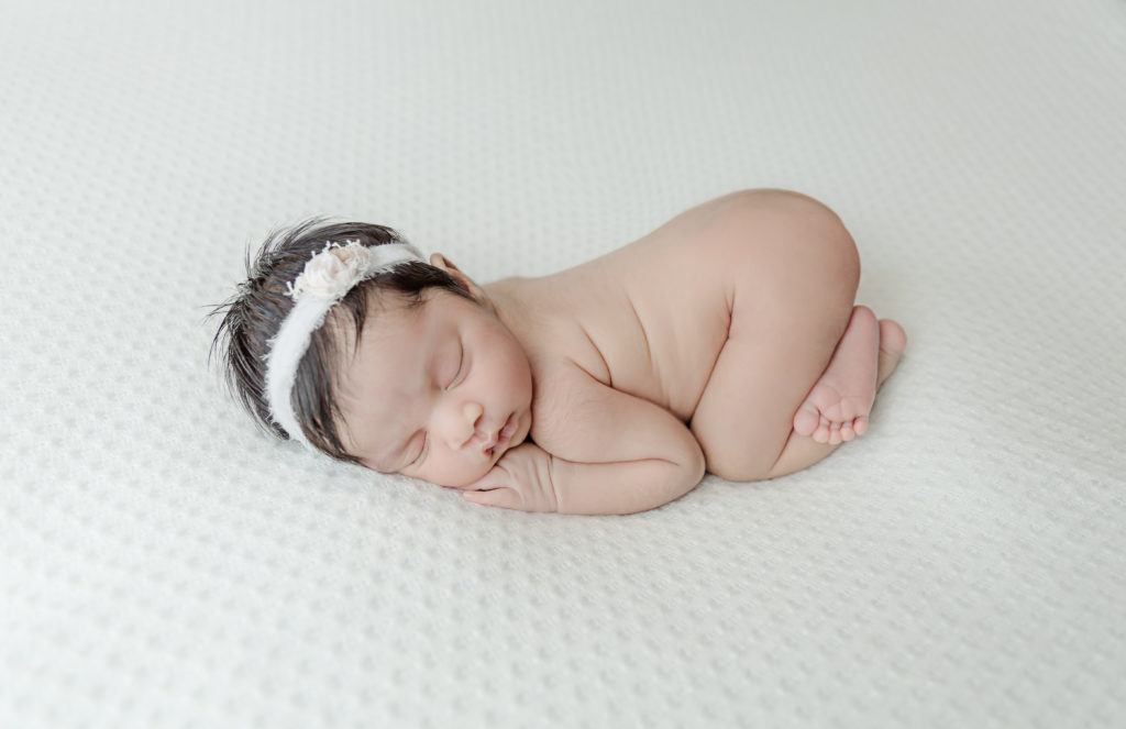 Naked posed baby photo white blanket