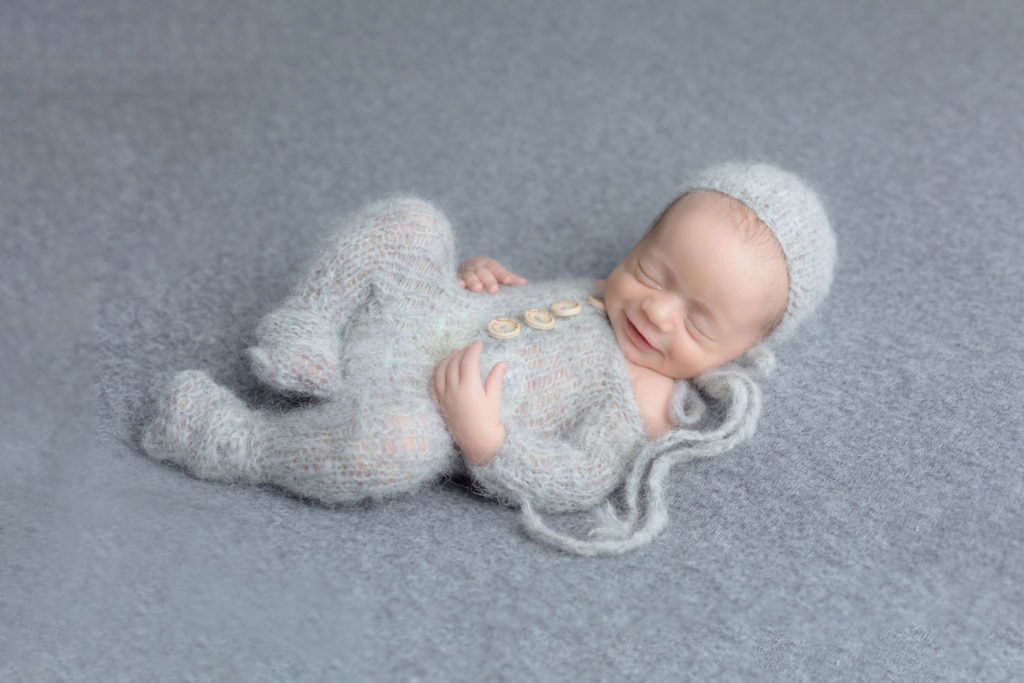 baby smiling in a grey outfit during his photo session, moms favourite photo