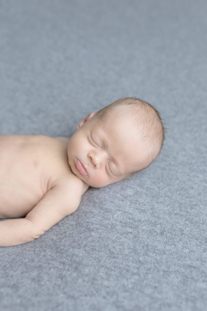 baby sleeping on grey blanket in a photo session ottawa