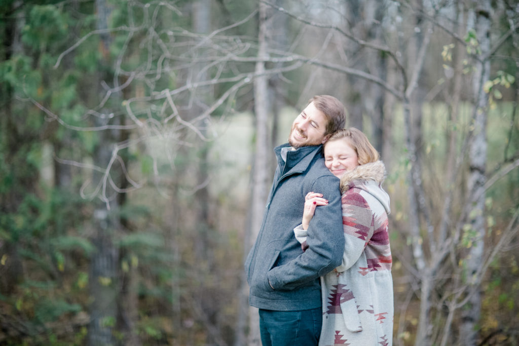 Couple scrunching noses during an engagement session in back yard in Carp Studio Grey Loft Best Tips