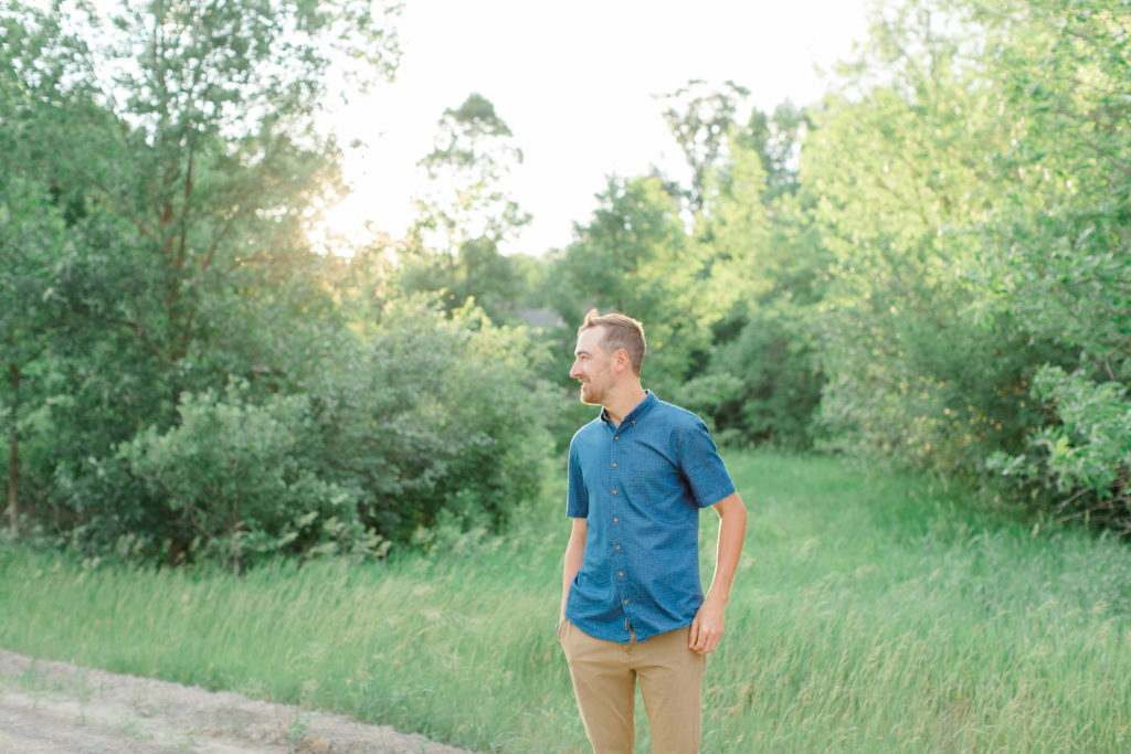 Groom to Be - posing during Engagement Session  Sunset - Natural Posing for Photo Session - Couples Photo Session Fun - Fun on the Farm - Farm Engagement Session - Blue and Brown Engagement Session Inspiration - Natural Engagement Session Posing - Ideas for what to wear for Engagement Photography, Modern Engagement Session Inspiration Wardrobe Ideas. Unsure of what to wear for your engagement photos, we've got you! Romantic brown with black leggings for Summer Engagement in Almonte. Grey Loft Studio is Ottawa's Wedding and Engagement Photographer for Real couples, showcasing photos that are modern, bright, and fun.