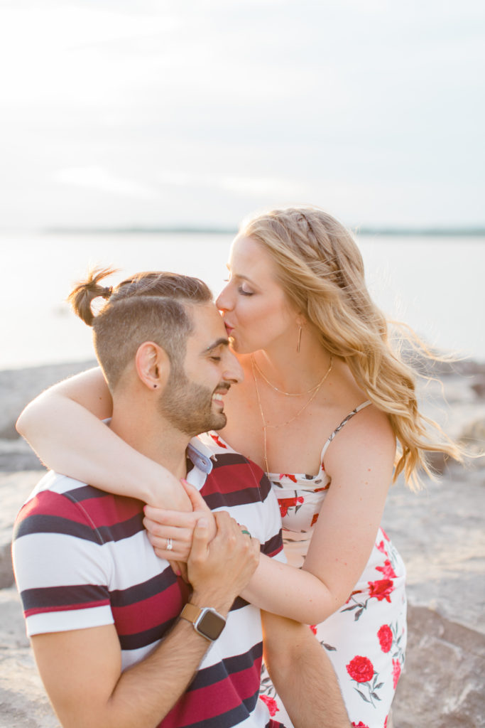 Cute Poses on the beach - Ideas for what to wear for Engagement Photography, Modern Engagement Session Inspiration Wardrobe Ideas. Unsure of what to wear for your engagement photos, we've got you! Romantic floral dress. Navy, Burgundy, & White T-shirt Polo & Navy shorts . Boat Shoes and Fancy. beaded sandals. Engagement at Britannia Beach, Nepean. Grey Loft Studio is Ottawa's Wedding and Engagement Photographer Videographer for Real couples, showcasing photos that are modern, bright, and fun.