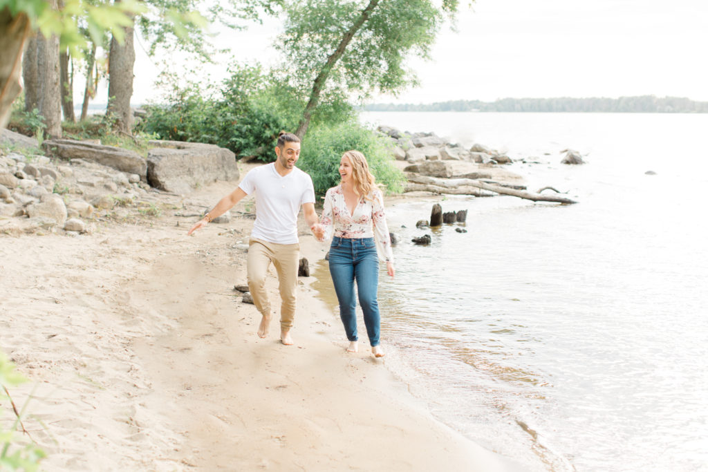 Walking on the Beach - Ideas for what to wear for Engagement Photography, Modern Engagement Session Inspiration Wardrobe Ideas. Unsure of what to wear for your engagement photos, we've got you! Romantic floral shirt & jeans.  White T-shirt & neutral pants . Boat Shoes and Fancy. beaded sandals. Engagement at Petrie Island, Orleans. Grey Loft Studio is Ottawa's Wedding and Engagement Photographer Videographer for Real couples, showcasing photos that are modern, bright, and fun.
