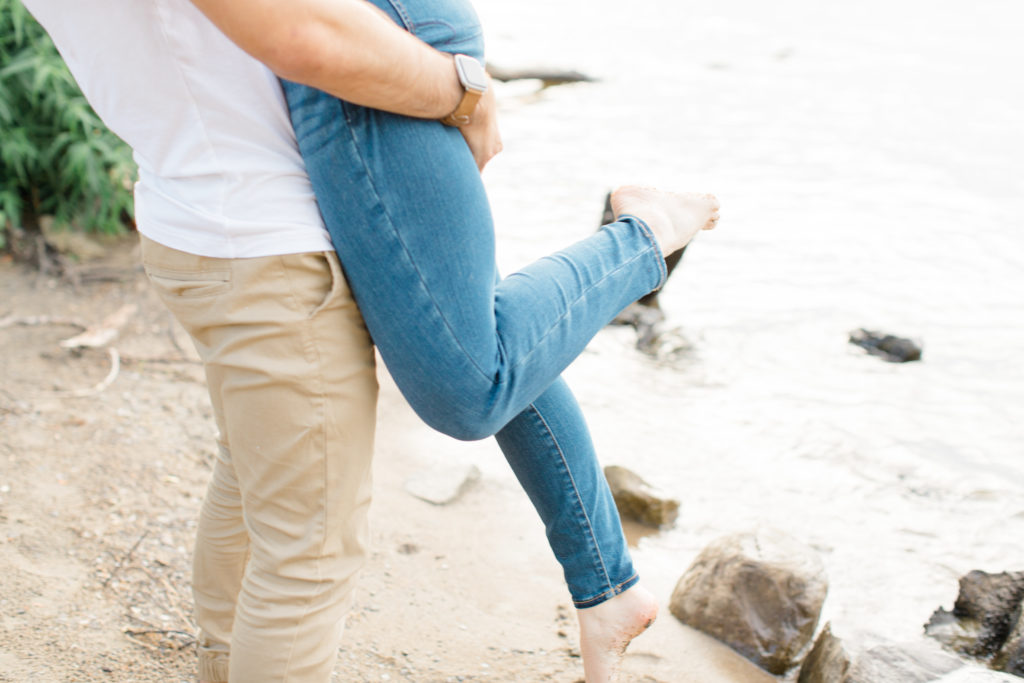 Lifting on the beach - Foot Shot - Ideas for what to wear for Engagement Photography, Modern Engagement Session Inspiration Wardrobe Ideas. Unsure of what to wear for your engagement photos, we've got you! Romantic floral shirt & jeans.  White T-shirt & neutral pants . Boat Shoes and Fancy. beaded sandals. Engagement at Petrie Island, Orleans. Grey Loft Studio is Ottawa's Wedding and Engagement Photographer Videographer for Real couples, showcasing photos that are modern, bright, and fun.
