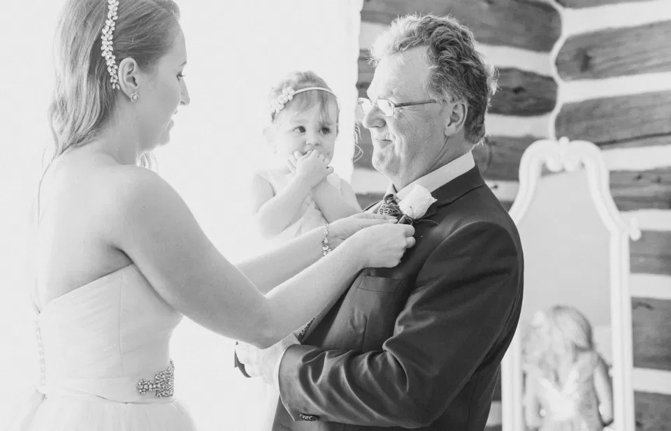 Bride putting on Boutonniere on her Wedding Day - Black and White