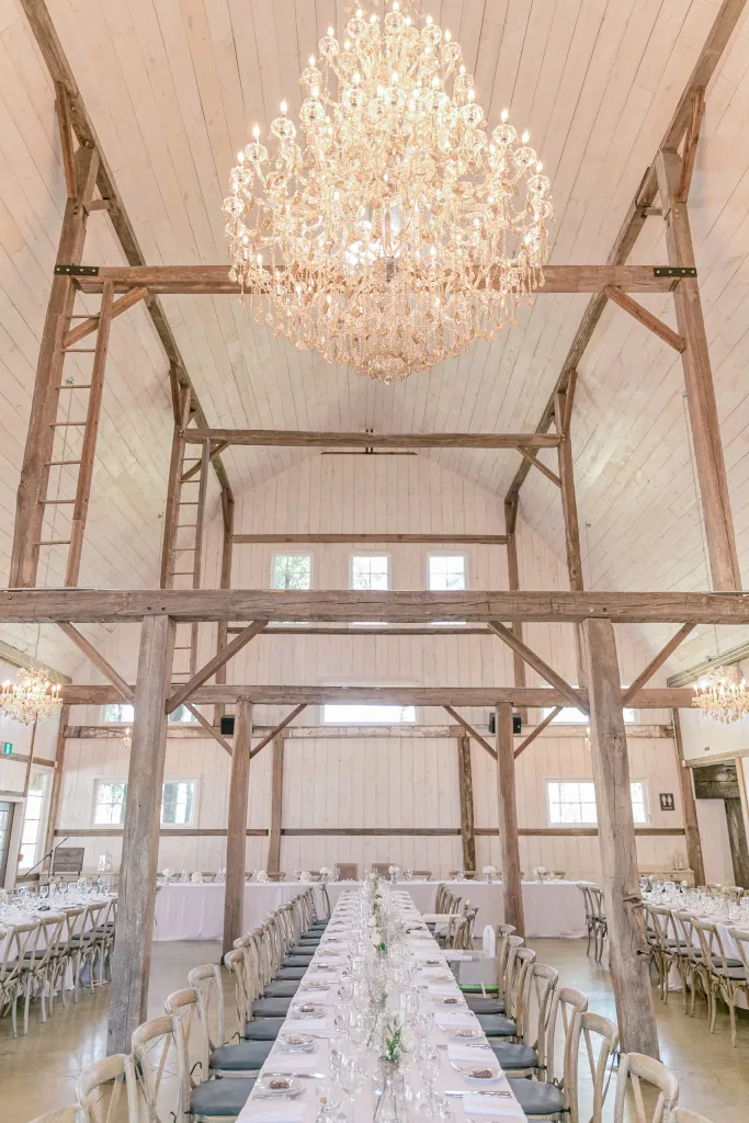 Large Ballroom Chandelier in Modern Barn - Minimalist Decor - Fun shots with Bridesmaids - Rose Gold Sequinned Dresses -  Stonefields Estate-  Bright and Airy - Natural Wedding Posing - Modern Wedding Blush &. Navy Wardrobe inspiration-  Romantic white with greenery, blush and navy theme. Grey Loft Studio is Stonefields Wedding and Engagement Photographer for Real couples, showcasing photos that are modern, bright, and fun.