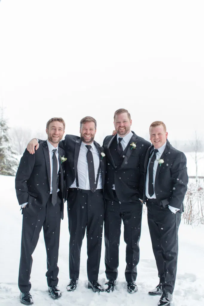 Snowy Groomsmen Photos - Winter Photos at Wedding - NYE Wedding - Natural Wedding Posing - Ideas for what to wear for Wedding on NYE Photography, Modern Wedding NYE Wardrobe inspiration- Must Have photo at Midnight -  Unsure of what to wear for your wedding, we've got you! Romantic white with greenery theme. Lace Wedding Dress in Ottawa. Grey Loft Studio is Ottawa's Wedding and Engagement Photographer for Real couples, showcasing photos that are modern, bright, and fun.