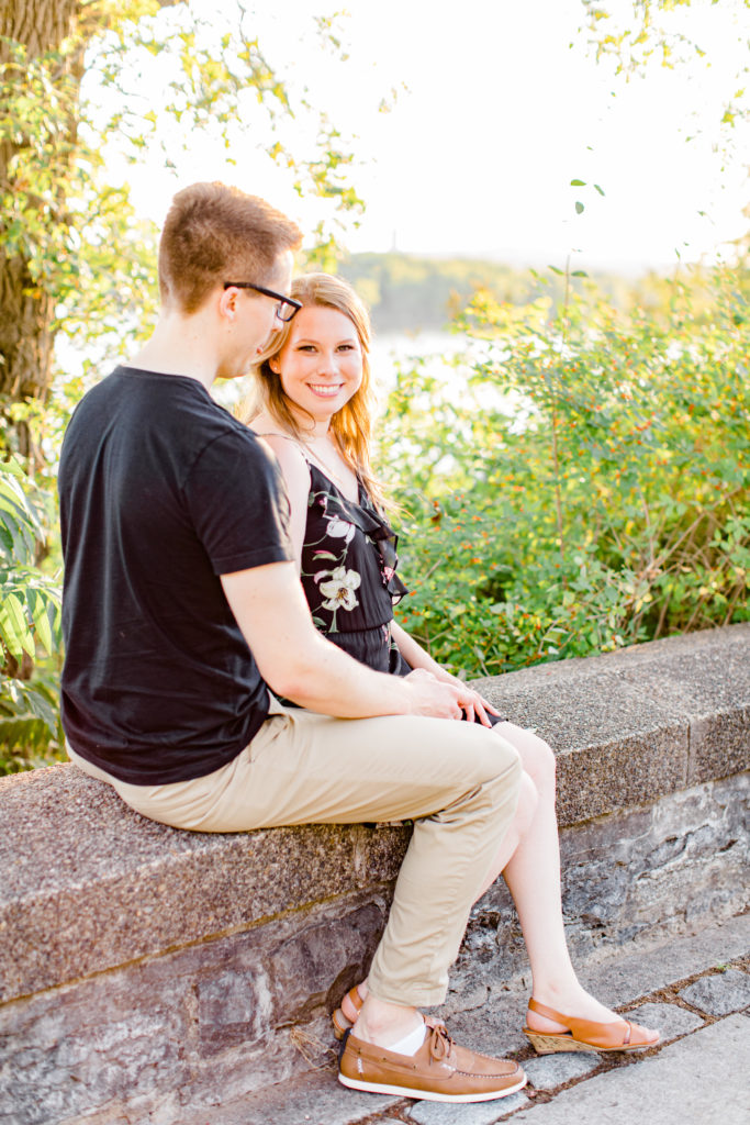 Sitting on Rock Wall-Cute Posing for Tall guys with short girls - Engagement Photo Poses- Posing close to Rideau Hall - Ideas for what to wear for Engagement Photography, Modern Engagement Session Inspiration Wardrobe Ideas. Unsure of what to wear for your engagement photos, we've got you! Romantic floral dress. Black Polo T-shirt & neutral pants . Boat Shoes and Fancy beaded wedges. Engagement downtown Ottawa. Grey Loft Studio is Ottawa's Wedding and Engagement Photographer Videographer for Real couples, showcasing photos that are modern, bright, and fun. Photographe Gatineau