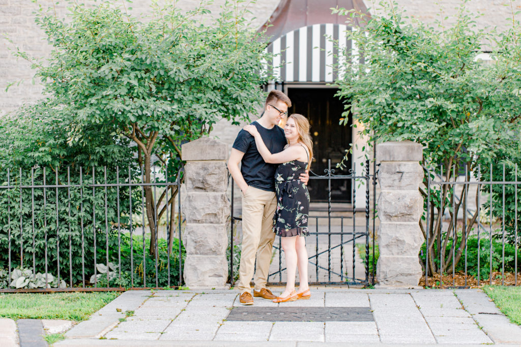 Cute Porch Session Ideas - Romantic Posing - Cute Posing for Tall guys with short girls - Engagement Photo Poses- Posing close to Rideau Hall - Ideas for what to wear for Engagement Photography, Modern Engagement Session Inspiration Wardrobe Ideas. Unsure of what to wear for your engagement photos, we've got you! Romantic floral dress. Black Polo T-shirt & neutral pants . Boat Shoes and Fancy beaded wedges. Engagement downtown Ottawa. Grey Loft Studio is Ottawa's Wedding and Engagement Photographer Videographer for Real couples, showcasing photos that are modern, bright, and fun. Photographe Gatineau -Posing on the Ottawa River