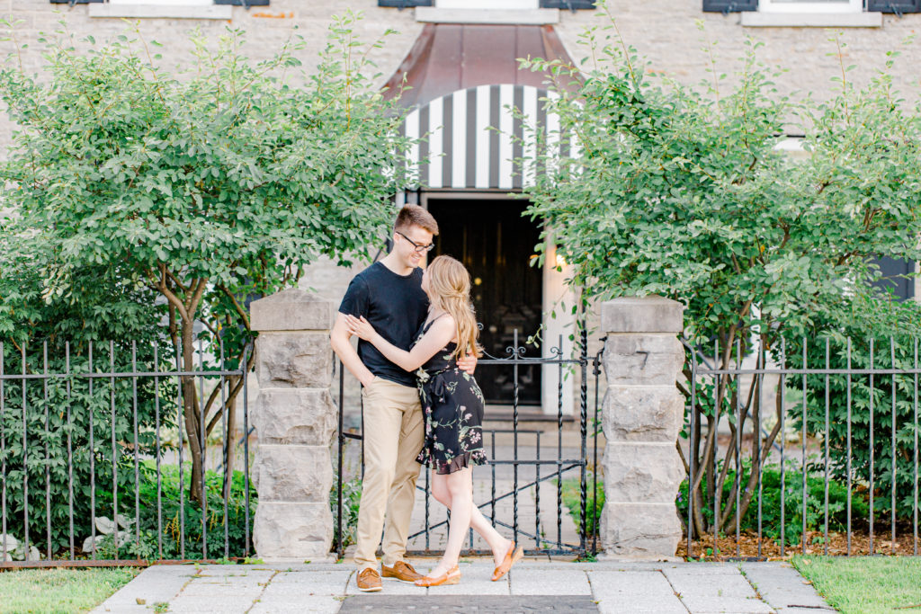 Cute Porch Session Ideas - Romantic Posing - Cute Posing for Tall guys with short girls - Engagement Photo Poses- Posing close to Rideau Hall - Ideas for what to wear for Engagement Photography, Modern Engagement Session Inspiration Wardrobe Ideas. Unsure of what to wear for your engagement photos, we've got you! Romantic floral dress. Black Polo T-shirt & neutral pants . Boat Shoes and Fancy beaded wedges. Engagement downtown Ottawa. Grey Loft Studio is Ottawa's Wedding and Engagement Photographer Videographer for Real couples, showcasing photos that are modern, bright, and fun. Photographe Gatineau -Posing on the Ottawa River