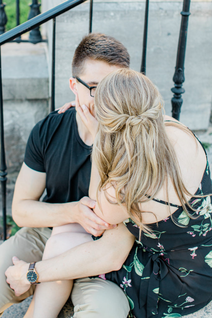 Engagement Session Hair Inspiration - Cute couple Posing while sitting on steps at Rideau Hall - Ideas for what to wear for Engagement Photography, Modern Engagement Session Inspiration Wardrobe Ideas. Unsure of what to wear for your engagement photos, we've got you! Romantic floral dress. Black Polo T-shirt & neutral pants . Boat Shoes and Fancy beaded wedges. Engagement downtown Ottawa. Grey Loft Studio is Ottawa's Wedding and Engagement Photographer Videographer for Real couples, showcasing photos that are modern, bright, and fun.