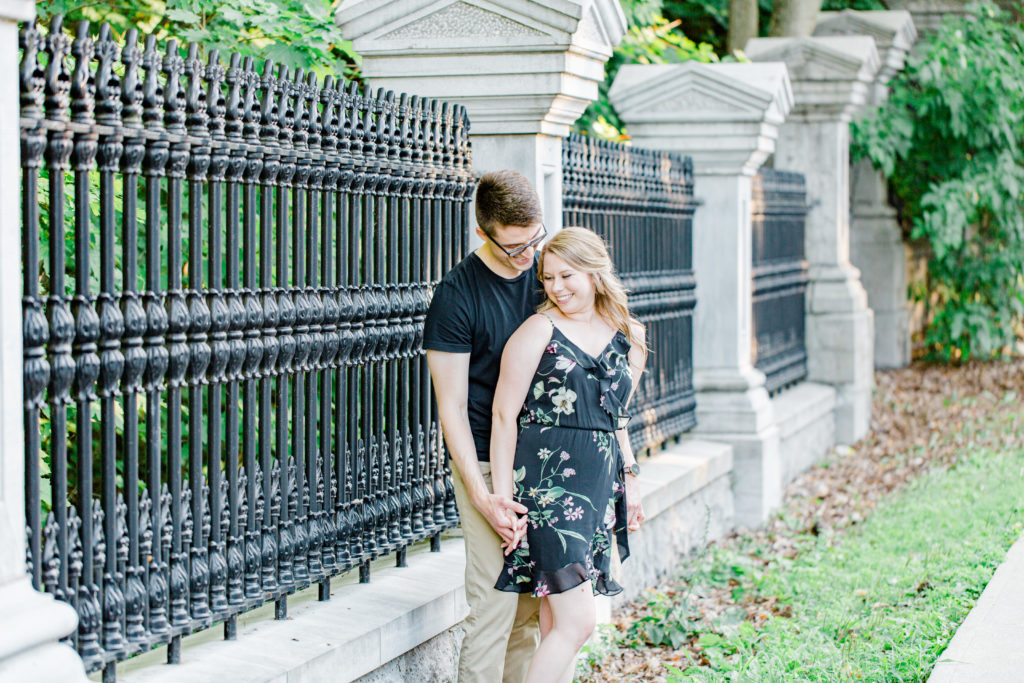 Holding Hands Shot - Engagement Photo Poses- Posing while at Rideau Hall - Ideas for what to wear for Engagement Photography, Modern Engagement Session Inspiration Wardrobe Ideas. Unsure of what to wear for your engagement photos, we've got you! Romantic floral dress. Black Polo T-shirt & neutral pants . Boat Shoes and Fancy beaded wedges. Engagement downtown Ottawa. Grey Loft Studio is Ottawa's Wedding and Engagement Photographer Videographer for Real couples, showcasing photos that are modern, bright, and fun.