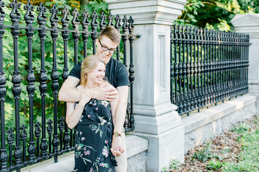 Cute Posing for Tall guys with short girls - Holding Hands Shot - Engagement Photo Poses- Posing while at Rideau Hall - Ideas for what to wear for Engagement Photography, Modern Engagement Session Inspiration Wardrobe Ideas. Unsure of what to wear for your engagement photos, we've got you! Romantic floral dress. Black Polo T-shirt & neutral pants . Boat Shoes and Fancy beaded wedges. Engagement downtown Ottawa. Grey Loft Studio is Ottawa's Wedding and Engagement Photographer Videographer for Real couples, showcasing photos that are modern, bright, and fun.