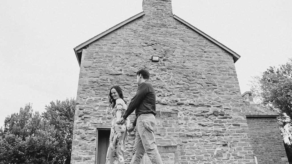 Couple walking- Black and White-Ideas for what to wear for Engagement Photography, Modern Engagement Session Inspiration Wardrobe Ideas. Unsure of what to wear for your engagement photos, we've got you! Romantic white with Pink Flower dress for Summer Engagement in Ottawa. Grey Loft Studio is Ottawa's Wedding and Engagement Photographer for Real couples, showcasing photos that are modern, bright, and fun.