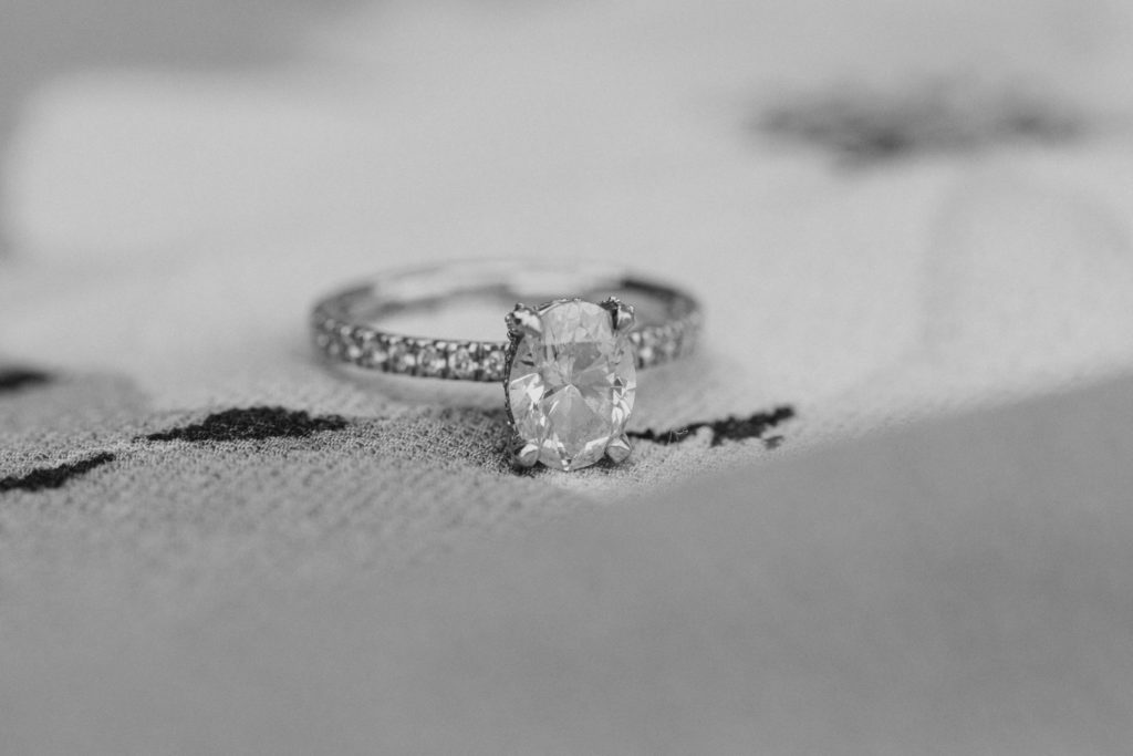 Ring Shot in Black and White - Couple Laughing in Black and White-Ideas for what to wear for Engagement Photography, Modern Engagement Session Inspiration Wardrobe Ideas. Unsure of what to wear for your engagement photos, we've got you! Romantic white with Pink Flower dress for Summer Engagement in Ottawa. Grey Loft Studio is Ottawa's Wedding and Engagement Photographer for Real couples, showcasing photos that are modern, bright, and fun.