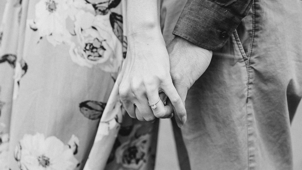 Couple's Hands in Black and White-Ideas for what to wear for Engagement Photography, Modern Engagement Session Inspiration Wardrobe Ideas. Unsure of what to wear for your engagement photos, we've got you! Romantic white with Pink Flower dress for Summer Engagement in Ottawa. Grey Loft Studio is Ottawa's Wedding and Engagement Photographer for Real couples, showcasing photos that are modern, bright, and fun.
