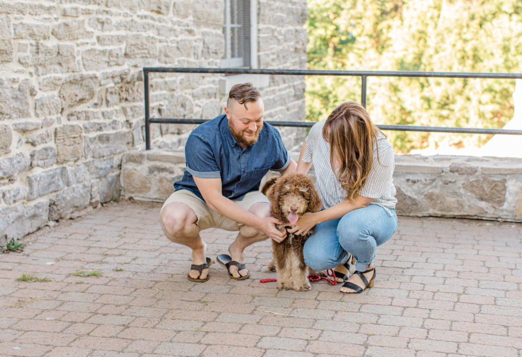 Chocolate Golden Doodle Puppy - grey loft studio -engagement session - Watson's Mill Engagement Session Manotick - Bright & Airy photography - Grey Loft Studio - Ottawa Wedding Photographer - Ottawa Wedding Videographer - Engagement Session Locations in Ottawa - Summer Engagement session - Light blue and Cream with casual jeans and strap sandals. Ottawa Photo Studio.