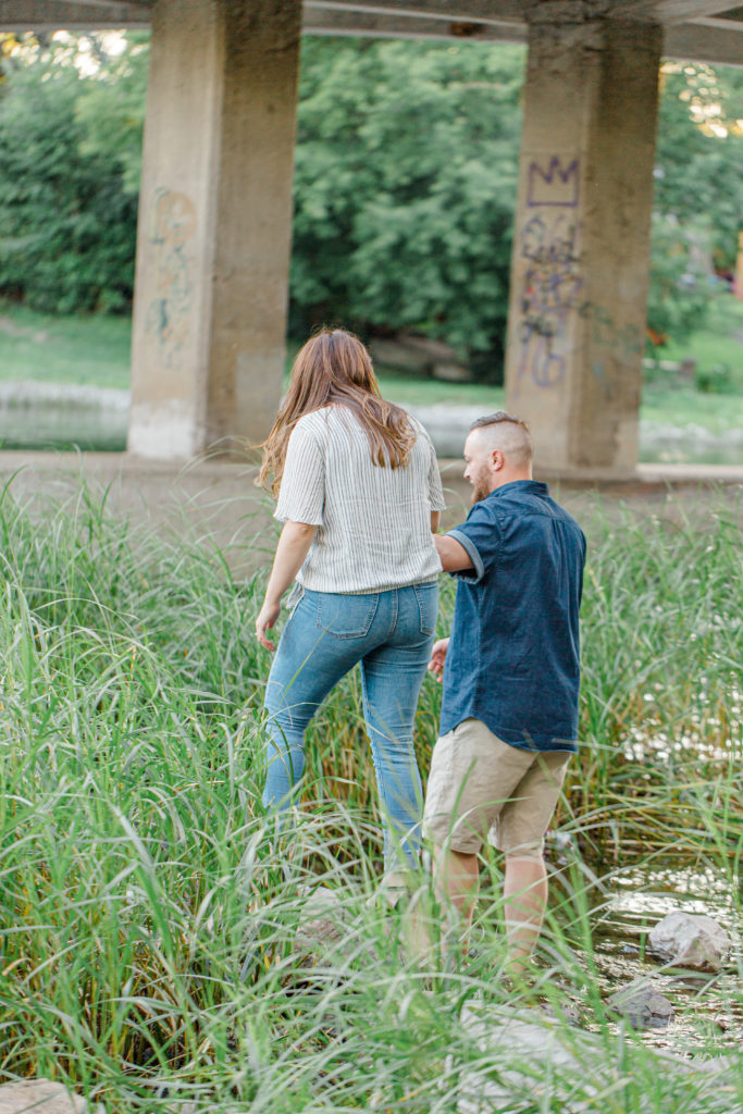 Couple walking during engagement session - Watson's Mill Engagement Session Manotick - Bright & Airy photography - Grey Loft Studio - Ottawa Wedding Photographer - Ottawa Wedding Videographer - Engagement Session Locations in Ottawa - Summer Engagement session - Light blue and Cream with casual jeans and strap sandals. Ottawa Photo Studio.