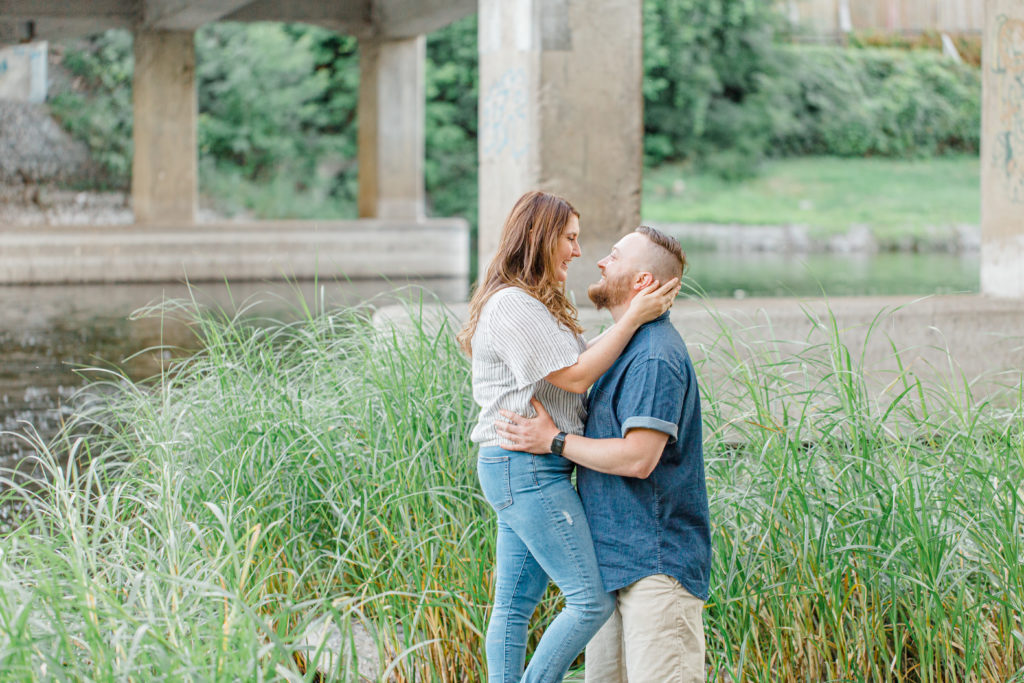Couple kissing after look -  during engagement session - Watson's Mill Engagement Session Manotick - Bright & Airy photography - Grey Loft Studio - Ottawa Wedding Photographer - Ottawa Wedding Videographer - Engagement Session Locations in Ottawa - Summer Engagement session - Light blue and Cream with casual jeans and strap sandals. Ottawa Photo Studio.