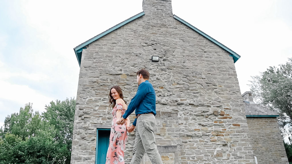 Couple walking near ruins -Ideas for what to wear for Engagement Photography, Modern Engagement Session Inspiration Wardrobe Ideas. Unsure of what to wear for your engagement photos, we've got you! Romantic white with Pink Flower dress for Summer Engagement in Ottawa. Grey Loft Studio is Ottawa's Wedding and Engagement Photographer for Real couples, showcasing photos that are modern, bright, and fun. Pinhey's Point Dunrobin.