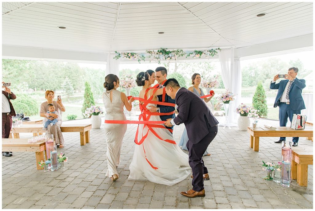 Traditional wrapping of streamers around bride & groom during first dance - Italian & Chinese Family - Wedding - Lisa & Pat - Grey Loft Studio - Wedding Photo & Video Team - Light and Airy - Ottawa Wedding Photographer & Videographer Orchard View Weddings 