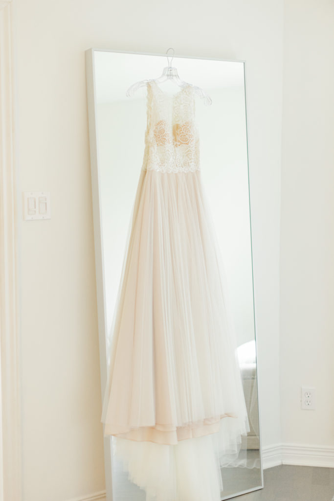 Dress hanging on a Mirror - Rose coloured tule with a lace Bodice. This lovely gown from White Satin Bridal Boutique. 